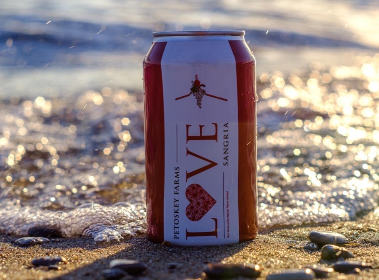 A can of Love Sangria on the beach.